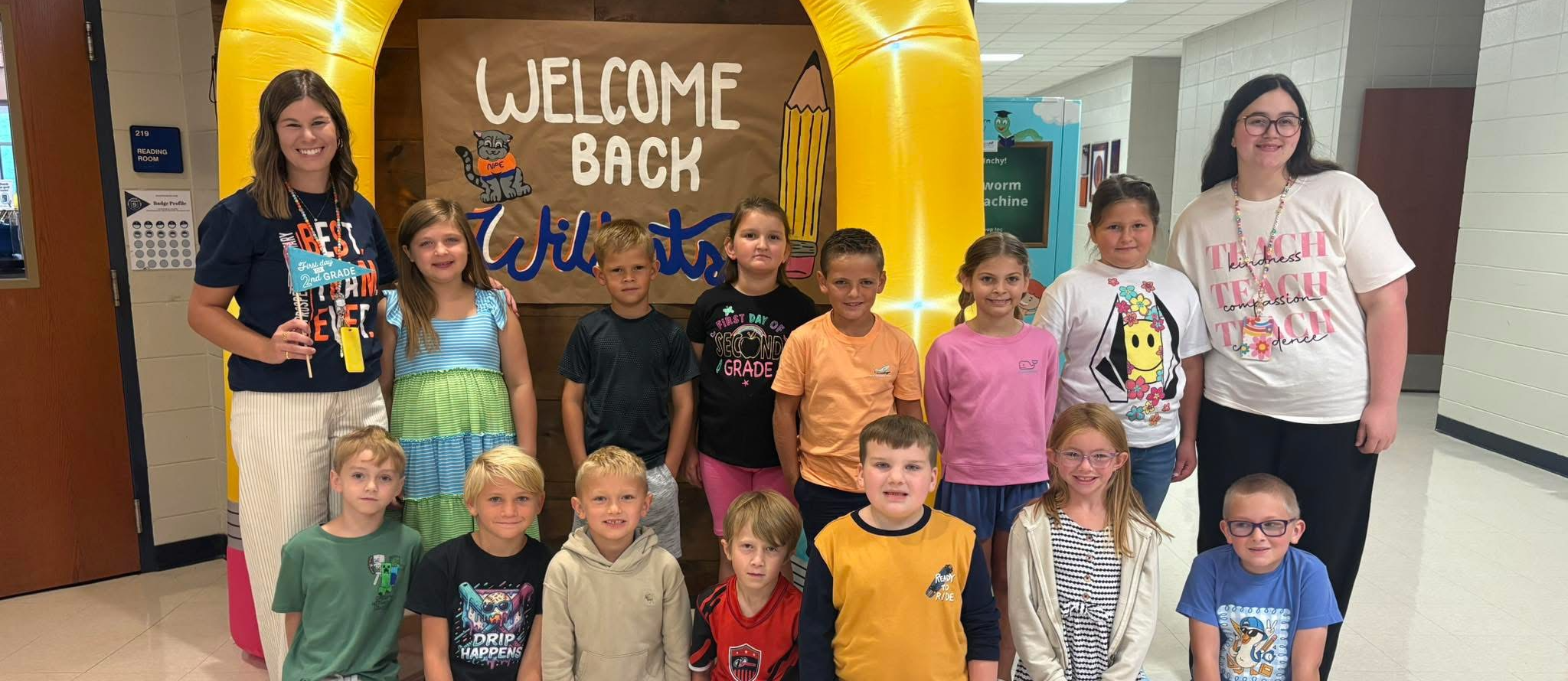 students in front of welcome back banner