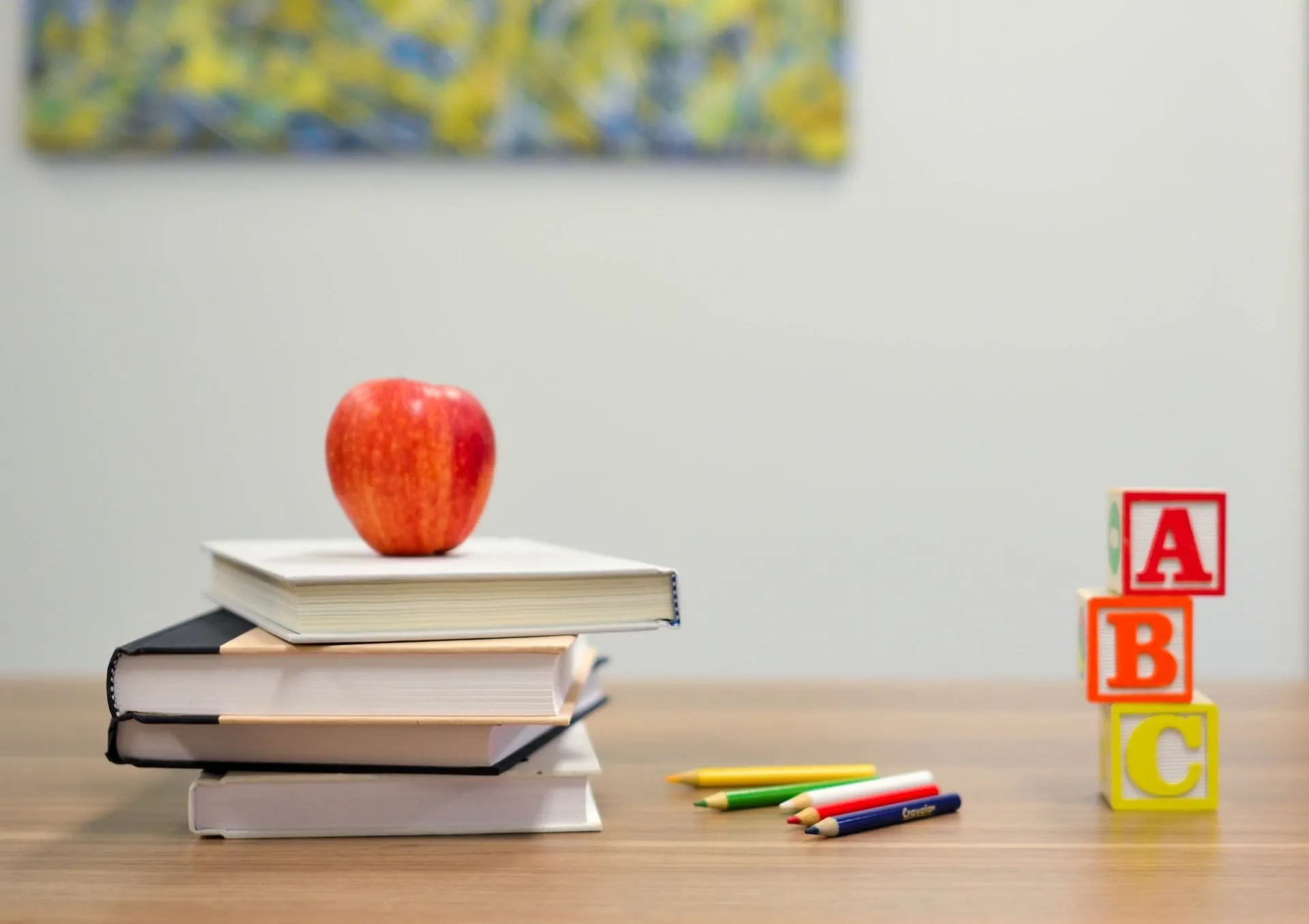 Apple sitting on top of some books.