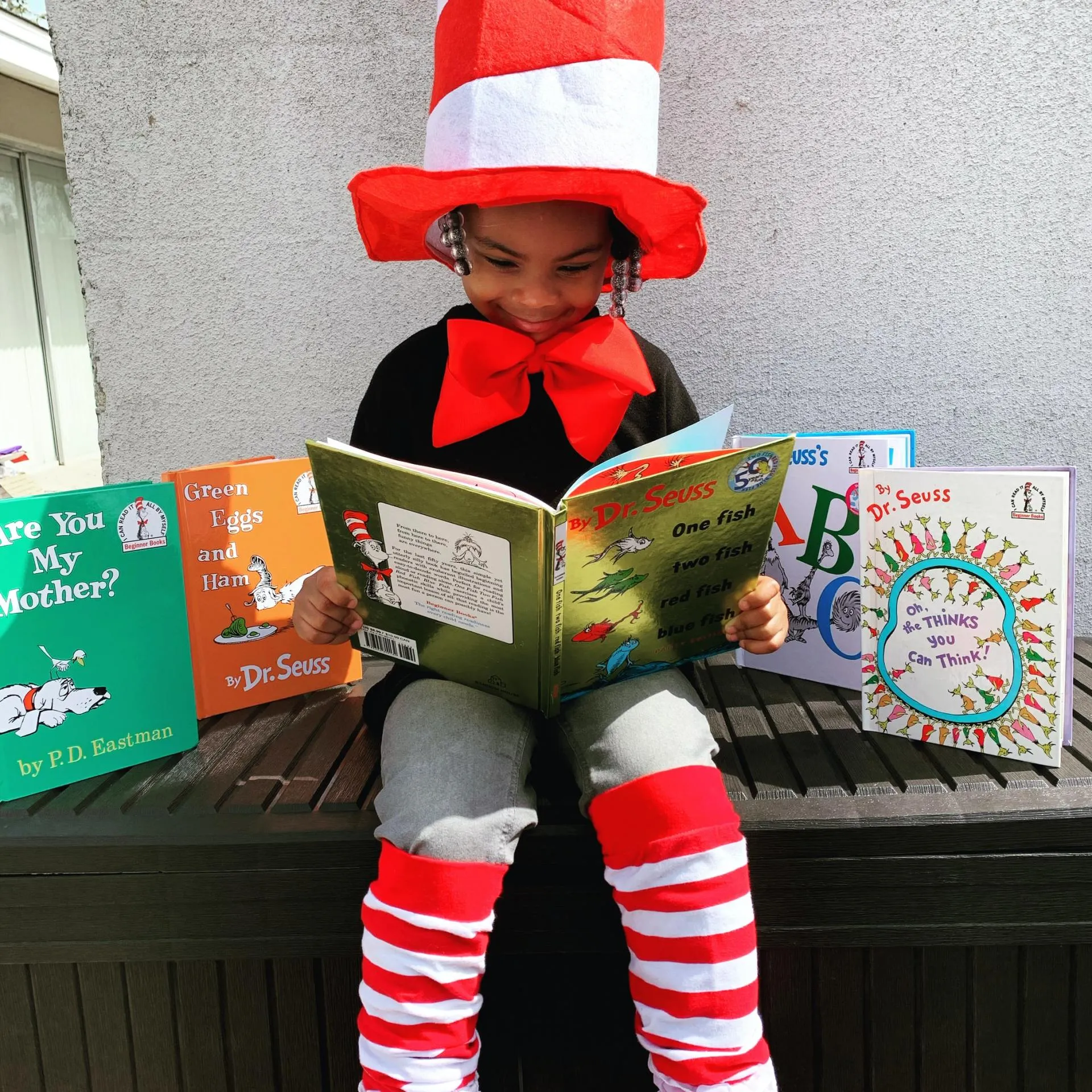 Student in Cat in the Hat hat reading Dr. Seuss