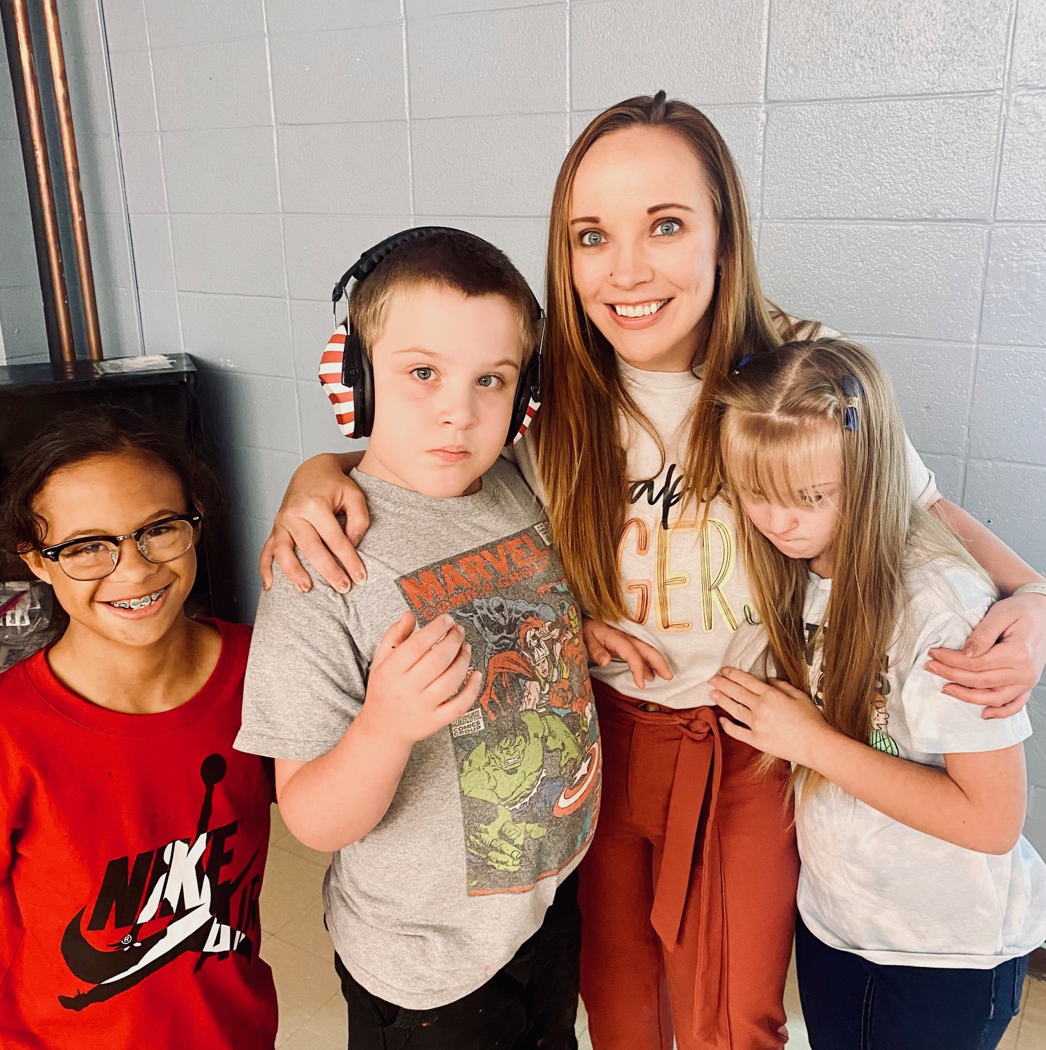 A nurse stands with three students as they pose for a picture