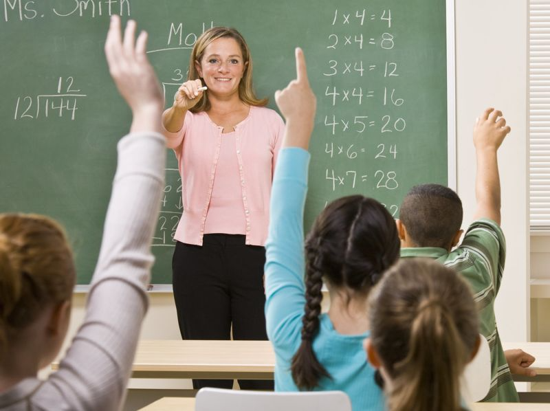 Teacher pointing at  students raising their hands