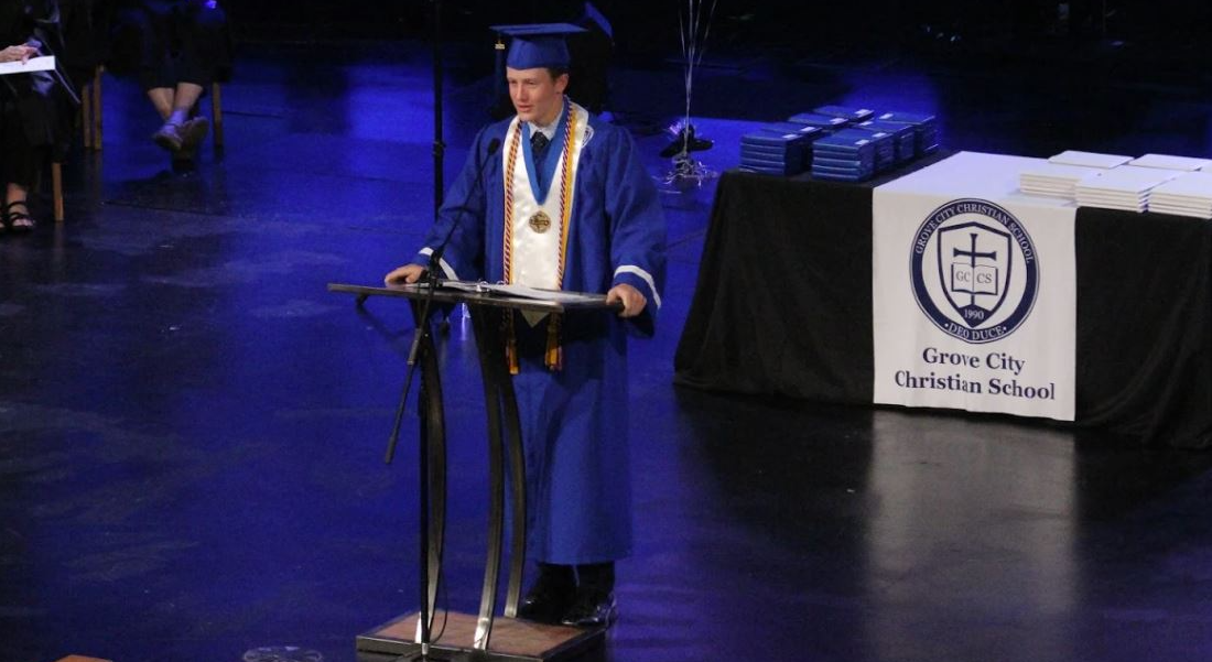 Valedictorian at a podium delivering the graduation address