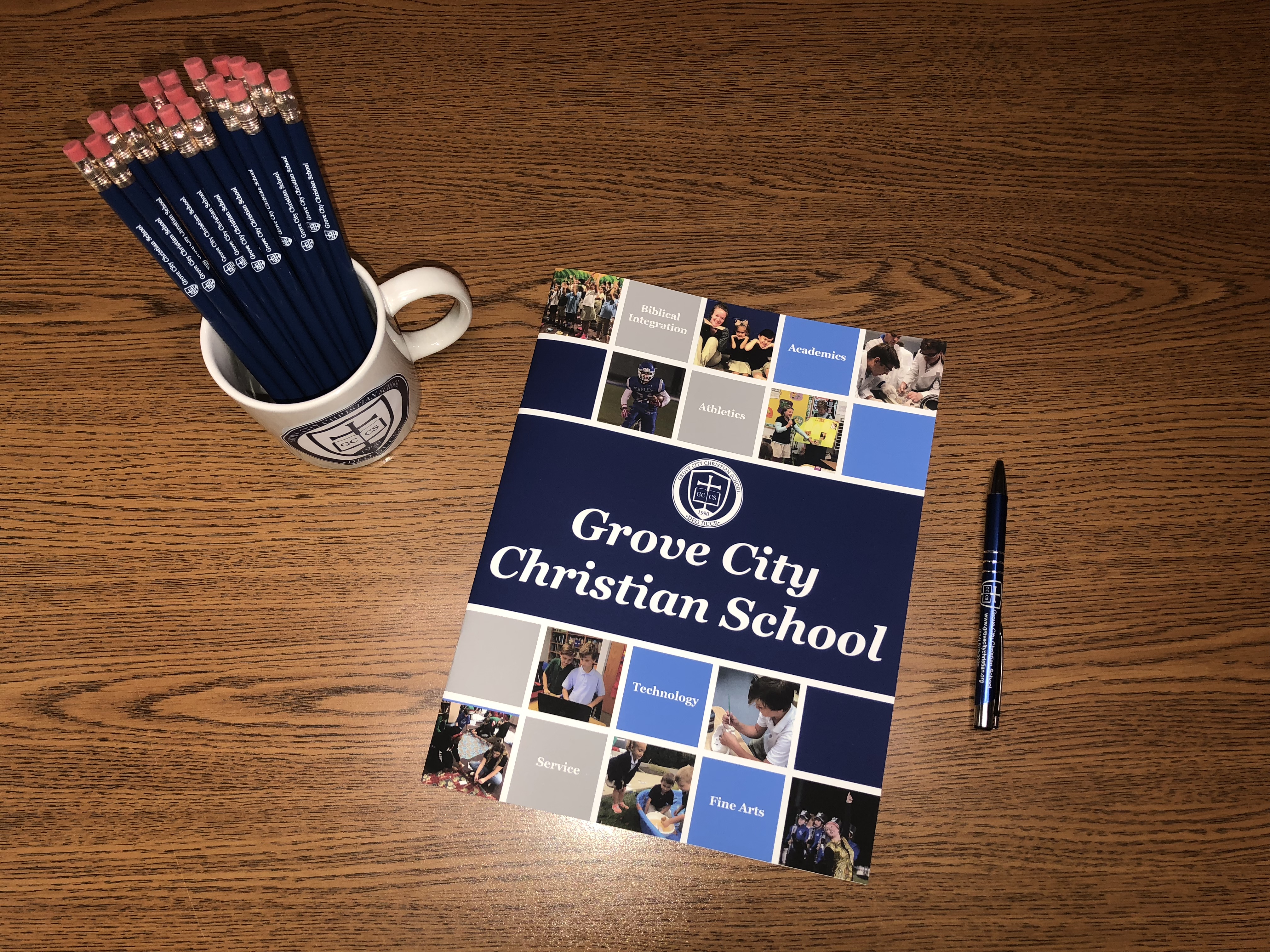 Coffee mug with pencils and GCCS admissions guide on desk
