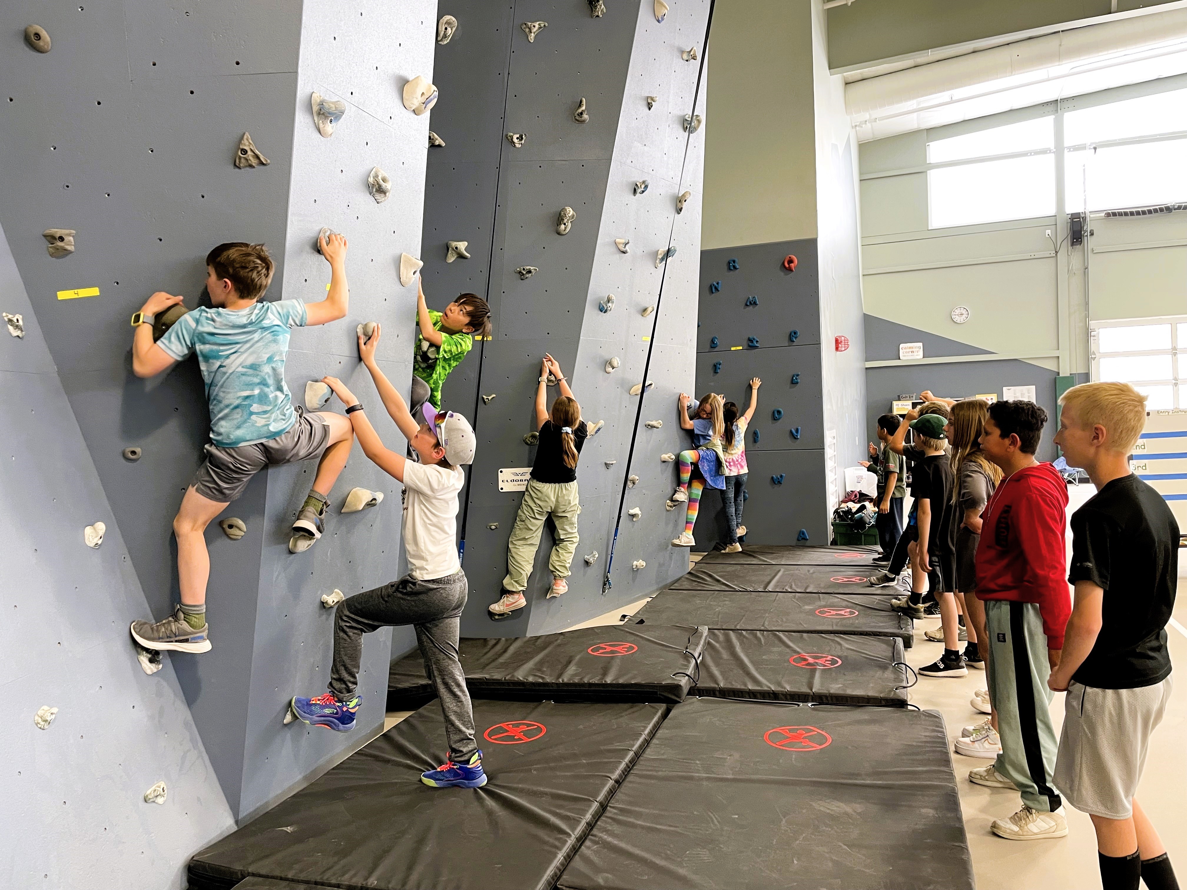 3rd graders bouldering a climbing wall