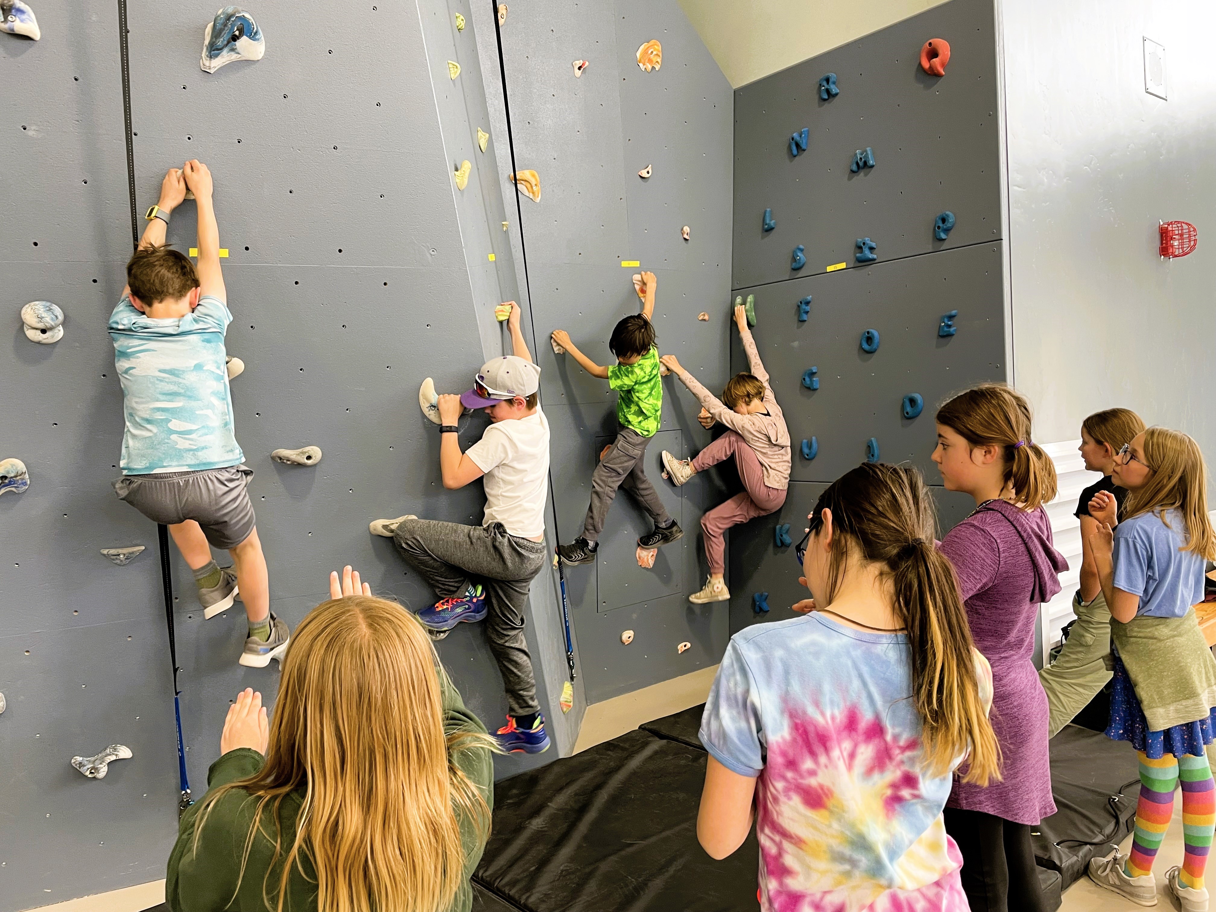 3rd graders bouldering a climbing wall