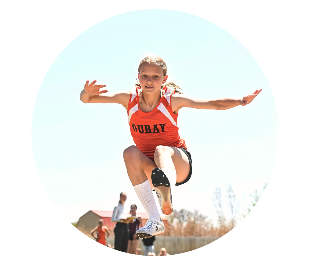 Track athlete midair during long jump competition.