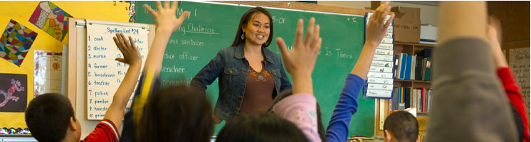 A teacher looking at her group with all raised hands.