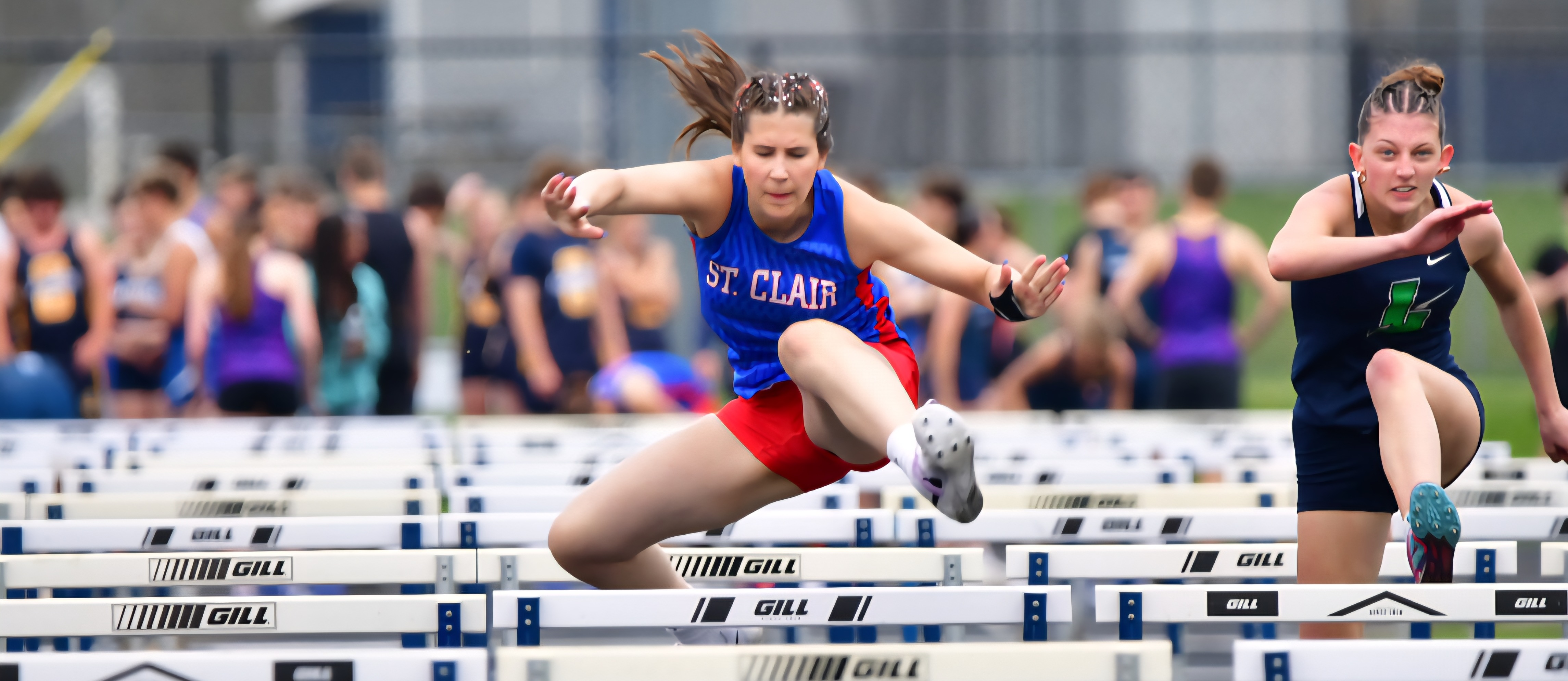 SCHS Track student jumping hurdles
