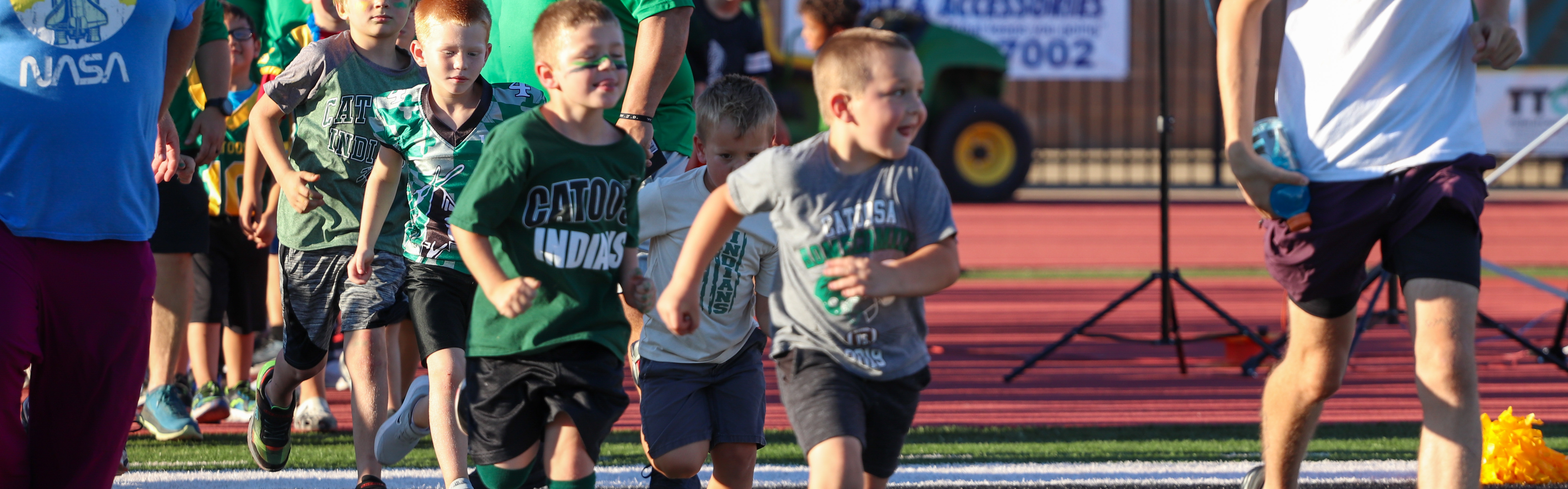 Elementary students running onto field