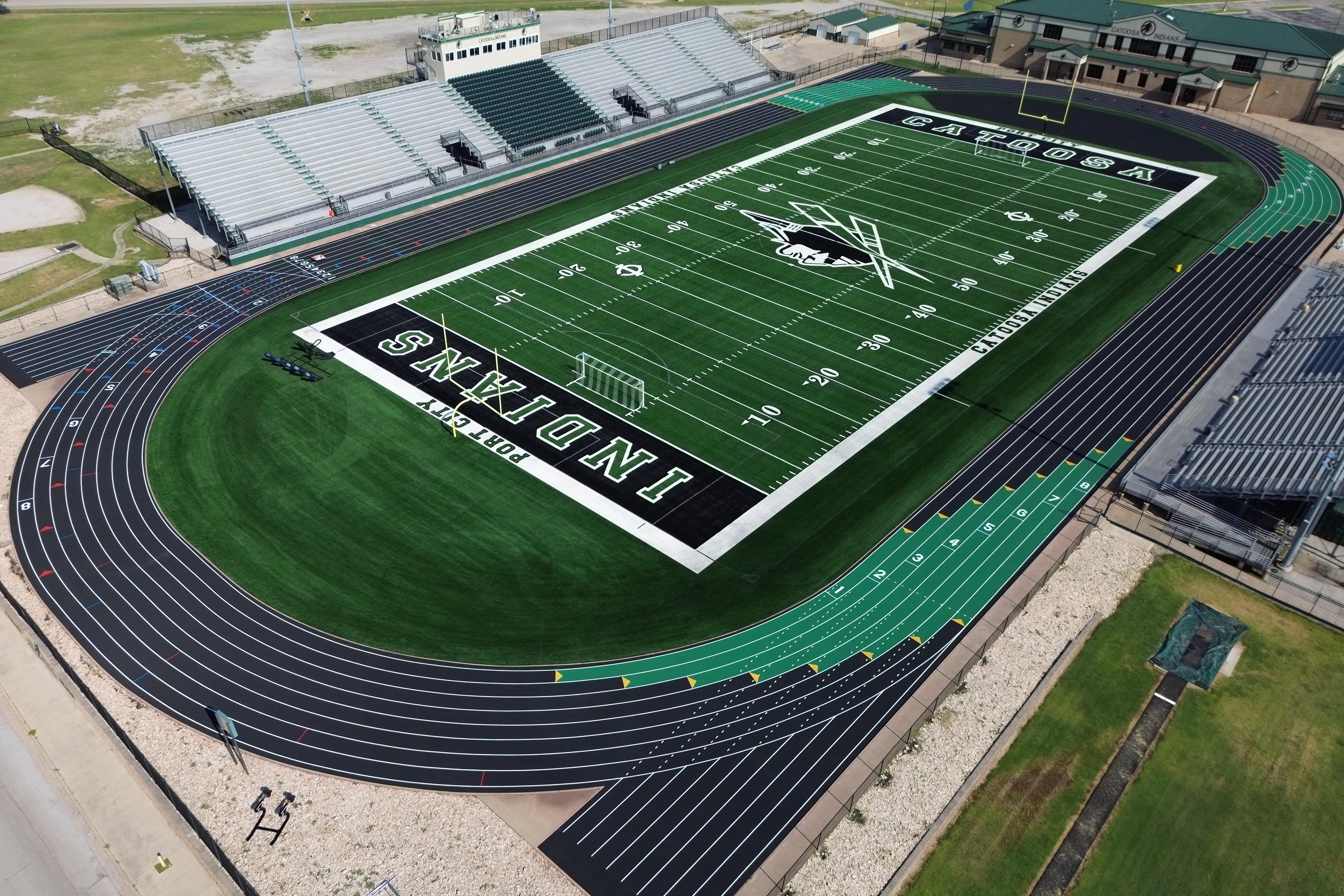 catoosa football team running out of low up football helmet wearing green jerseys