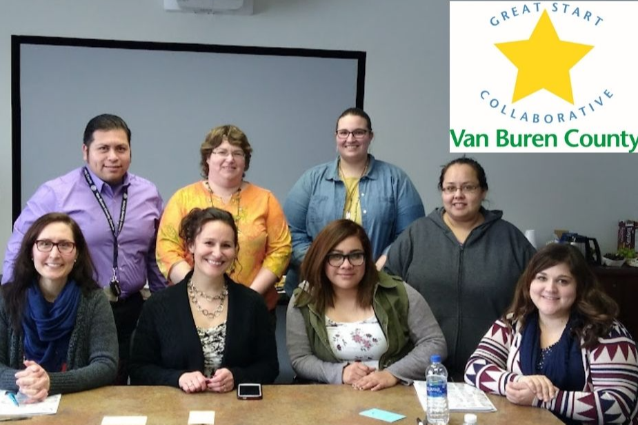 Photo of Great Start Collaborative Staff around a table with the Van Buren County Great Start Collaborative logo  in the upper right hand corner.