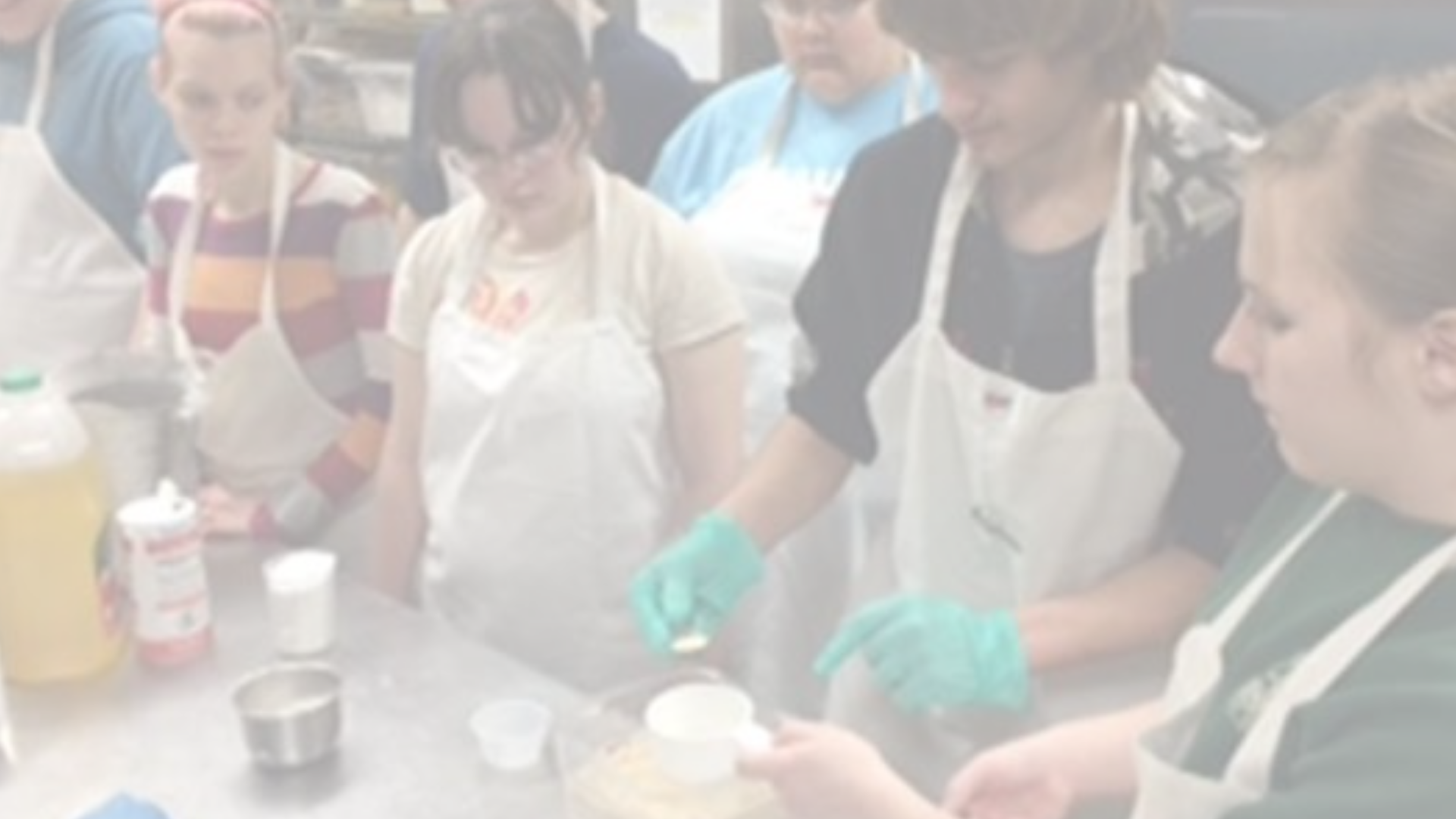 group of young adult students cooking in commercial kitchen