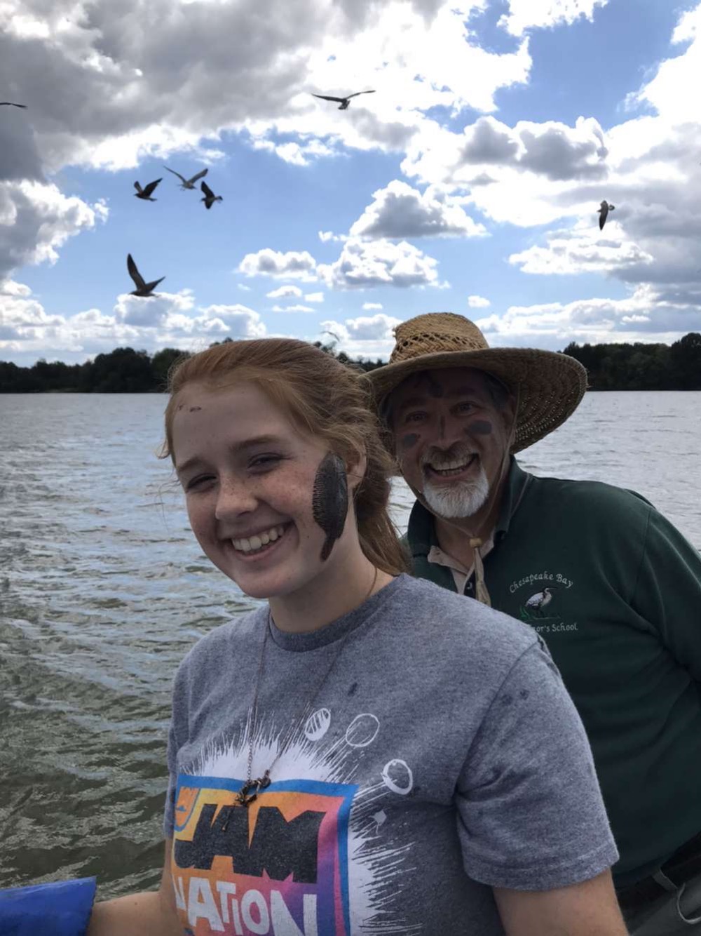 Man and girl on water with student and teacher in the CBGS program posing for a picture