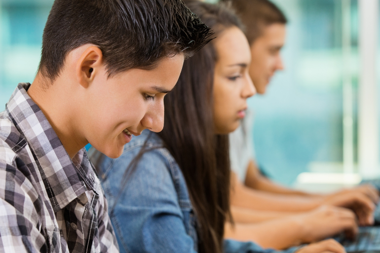 picture of three students working on a computer.