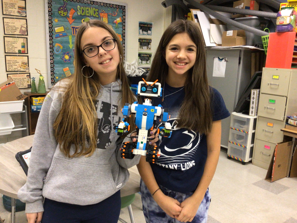 Girls holding robot car they made