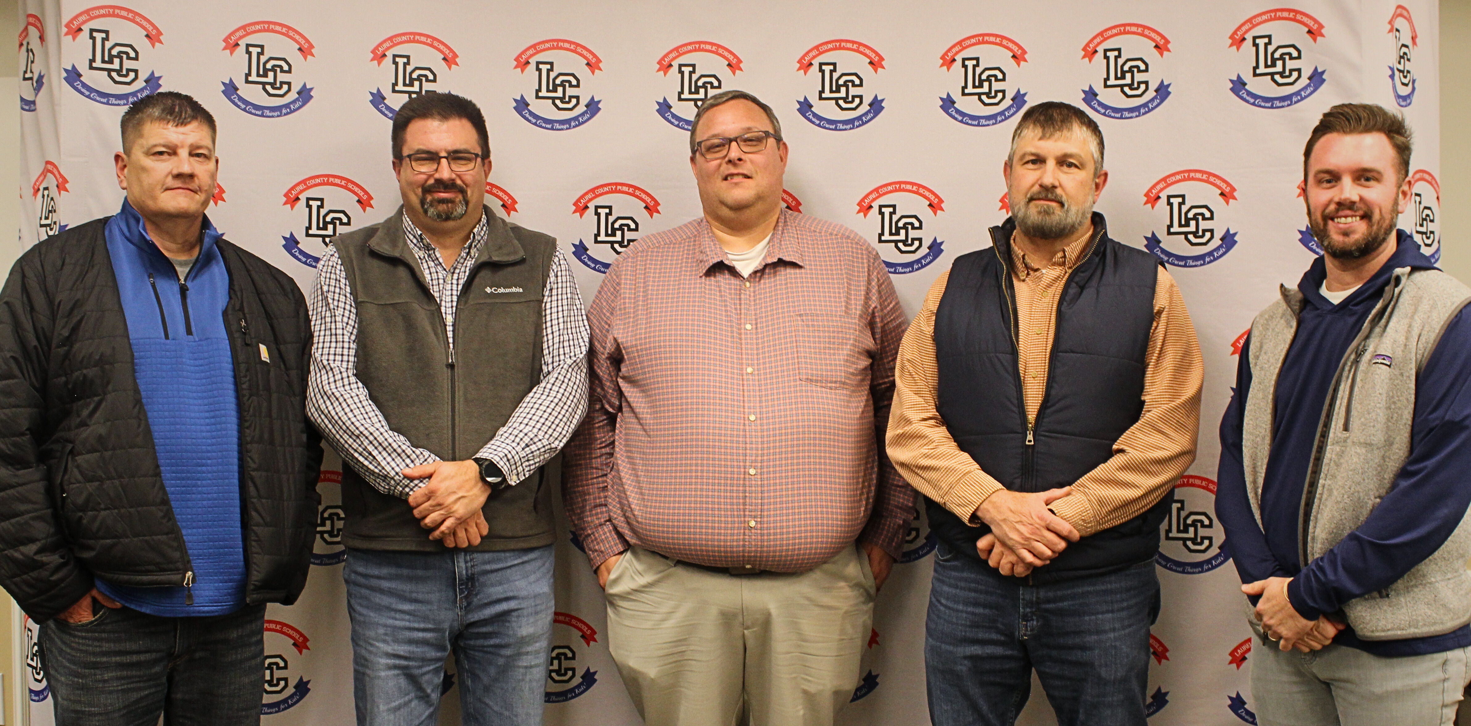 Current Board of Education members in front of backdrop