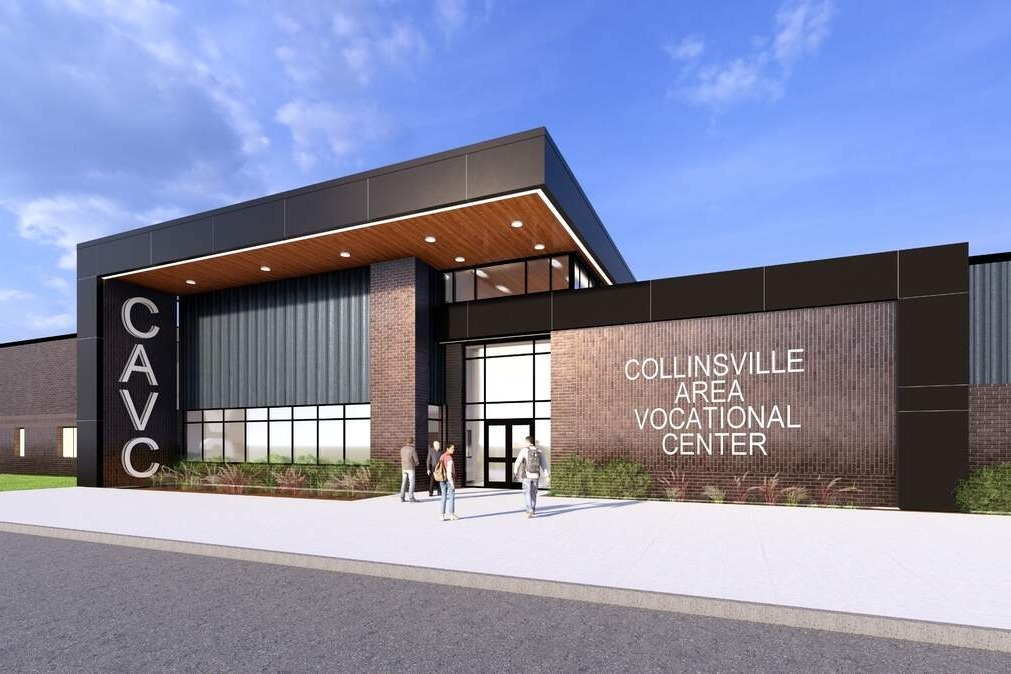 Conceptual design of a vocational center with a large glass entrance, a brick wall, and a clear sky.
