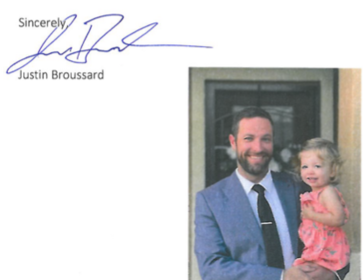 Justin Broussard signature and a photograph of him holding his daughter