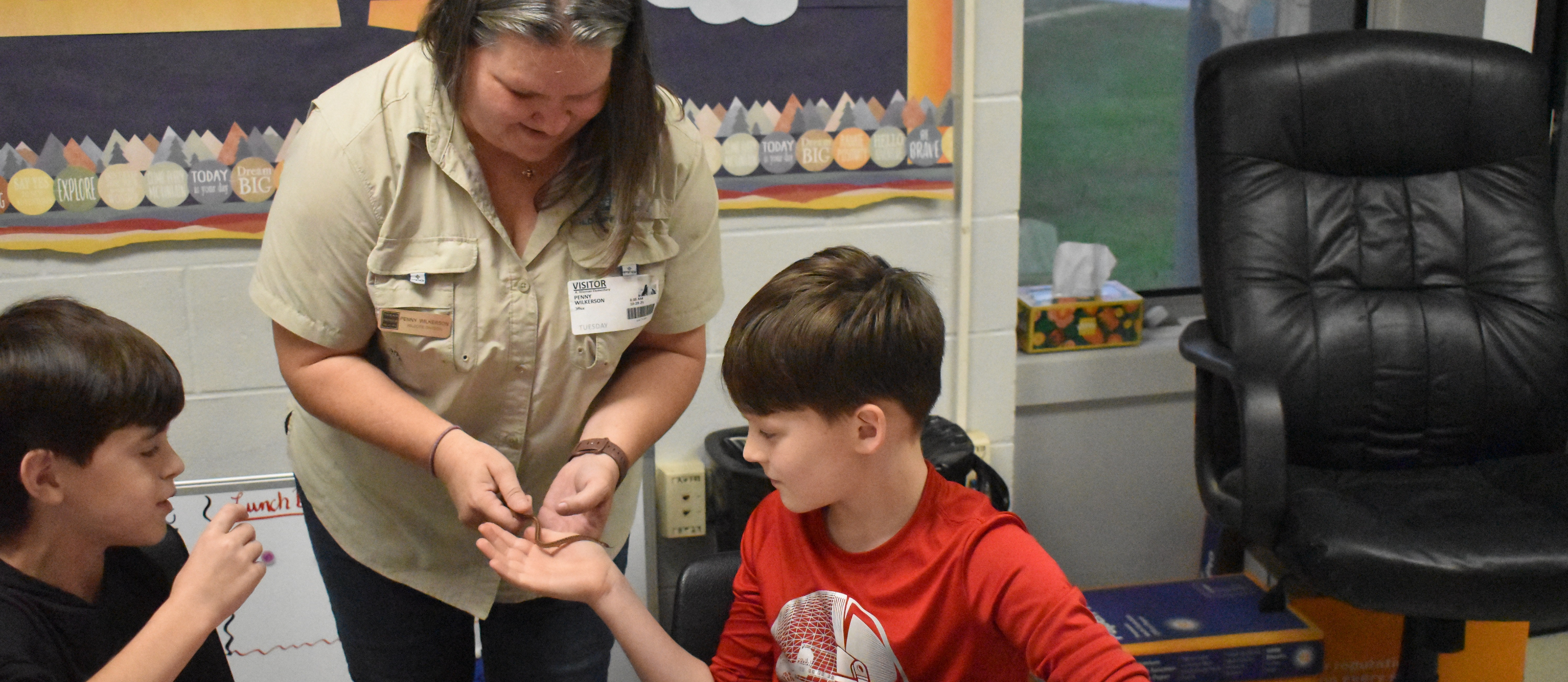 Wildlife biologist Penny Wilkerson shows 4th graders a  Dekay's brown snake