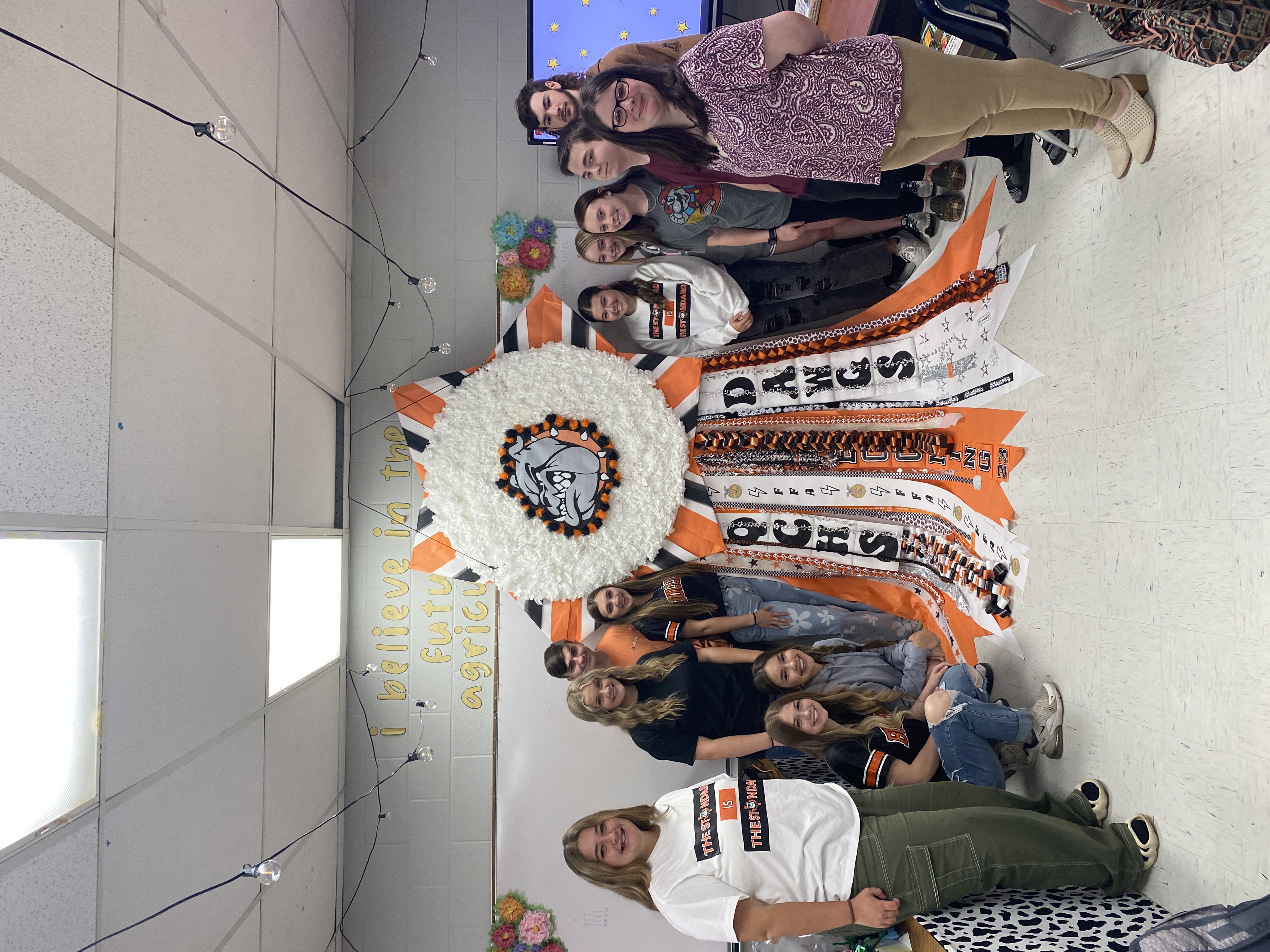 students with giant homecoming mum