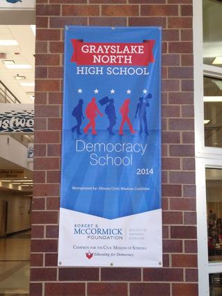 grayslake north high school democracy banner in blue hung on a brick column