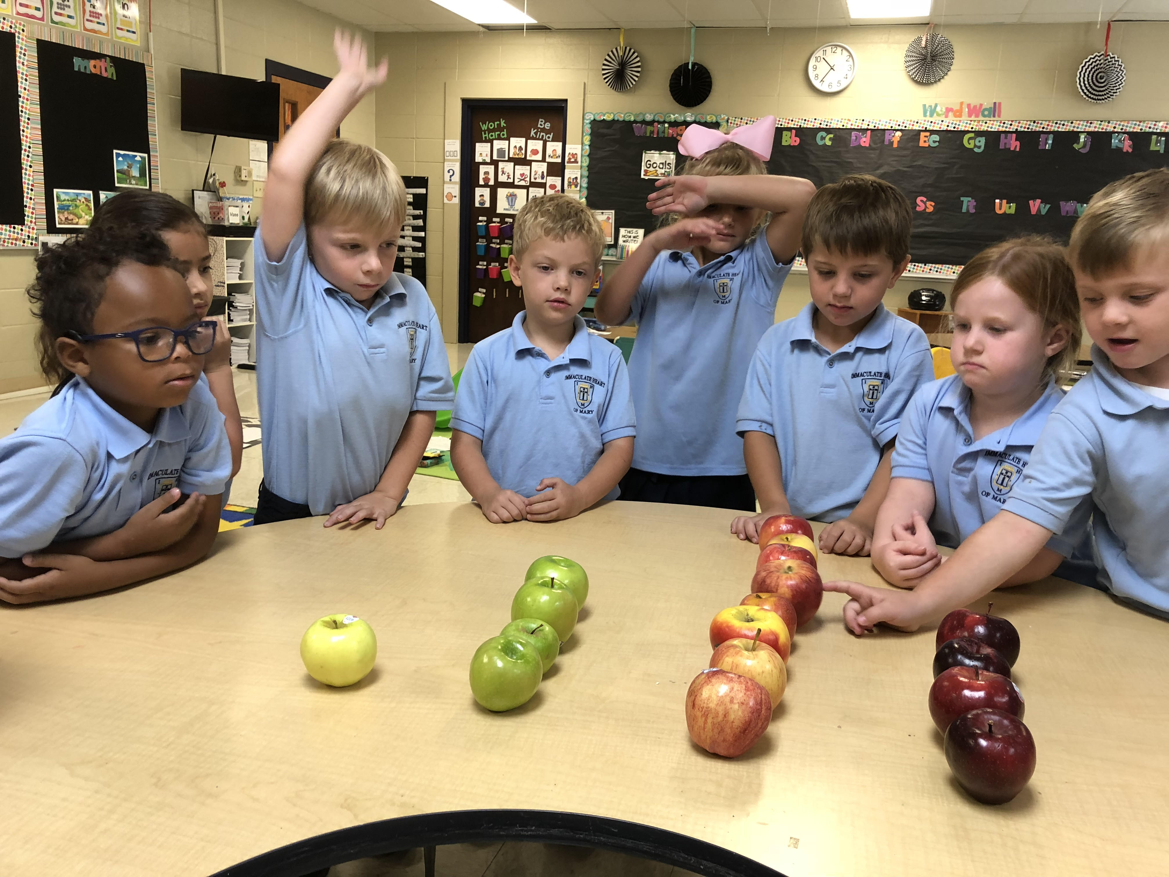 A group of students counting with apples