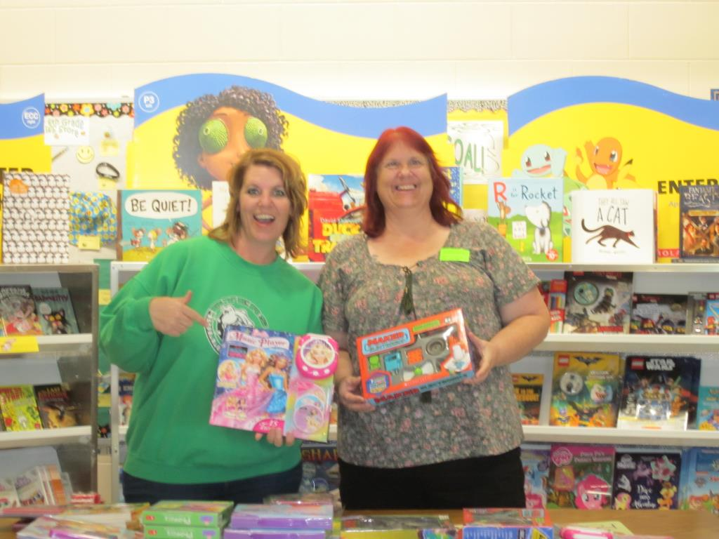 Staff members at Byers Elementary Book Fair showing books