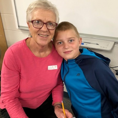 A student and his grandparent visits in class for Grandparents Day
