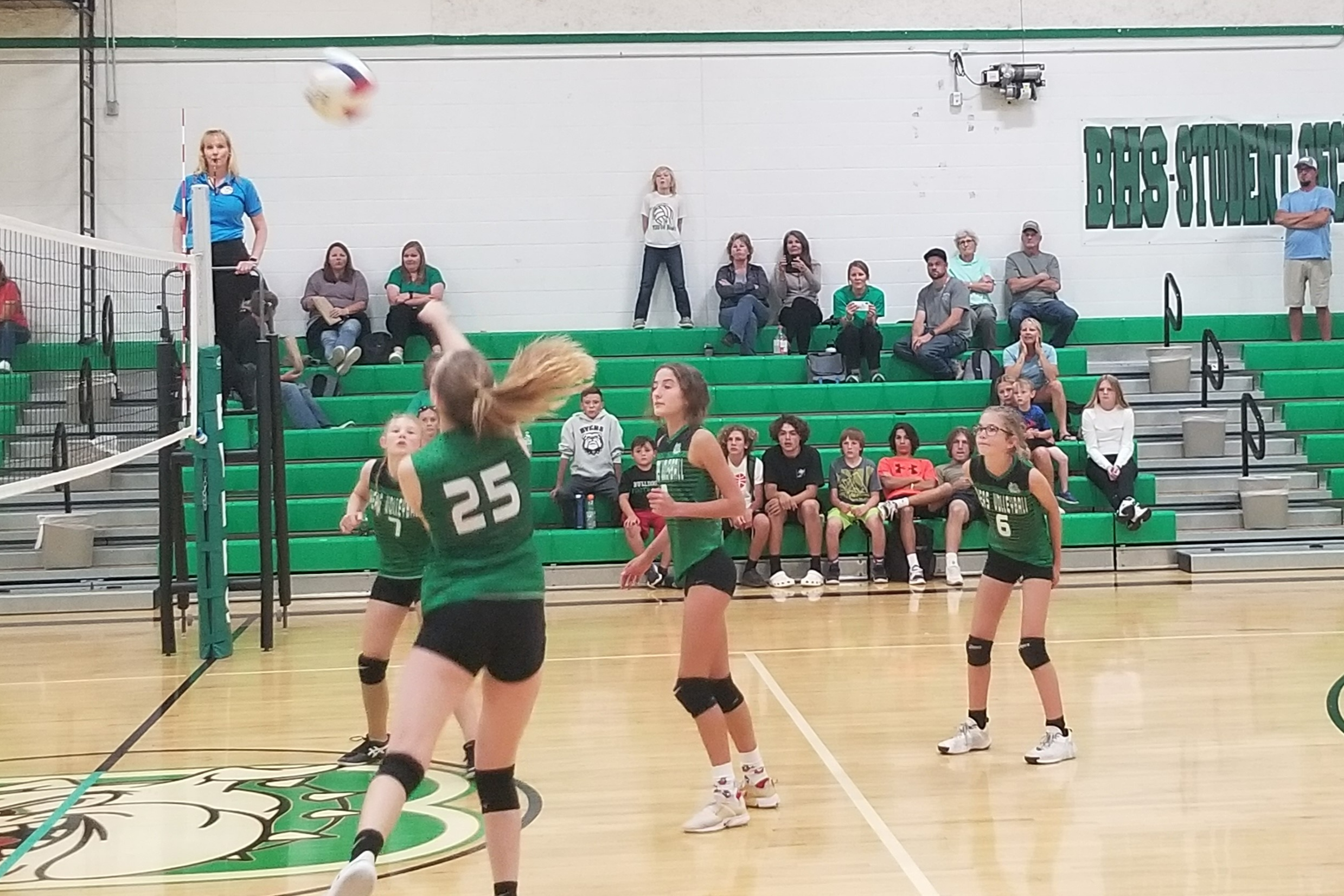 JH Volleyball Byers player #25 passing the ball over the net after a set.