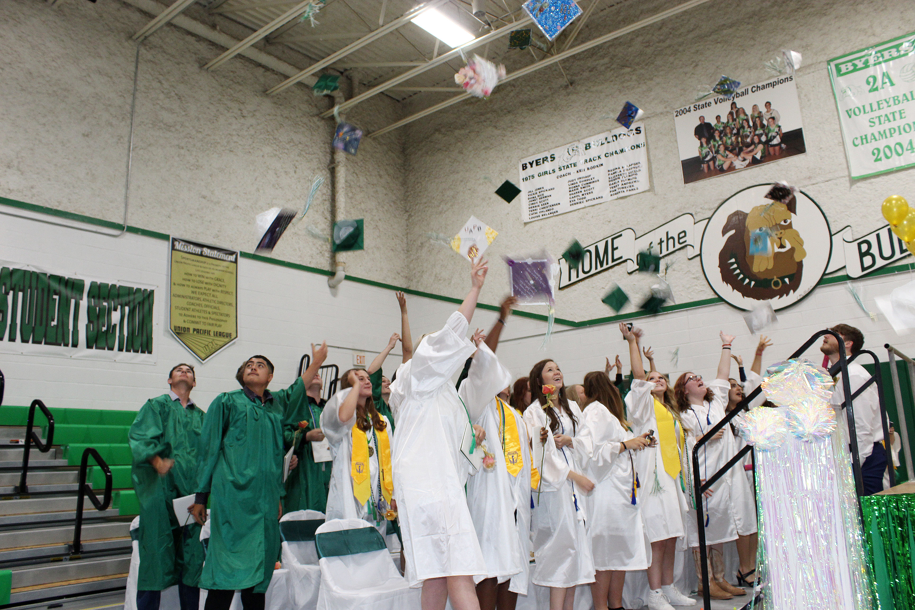 Large group of High School Seniors throwing their caps in the air.