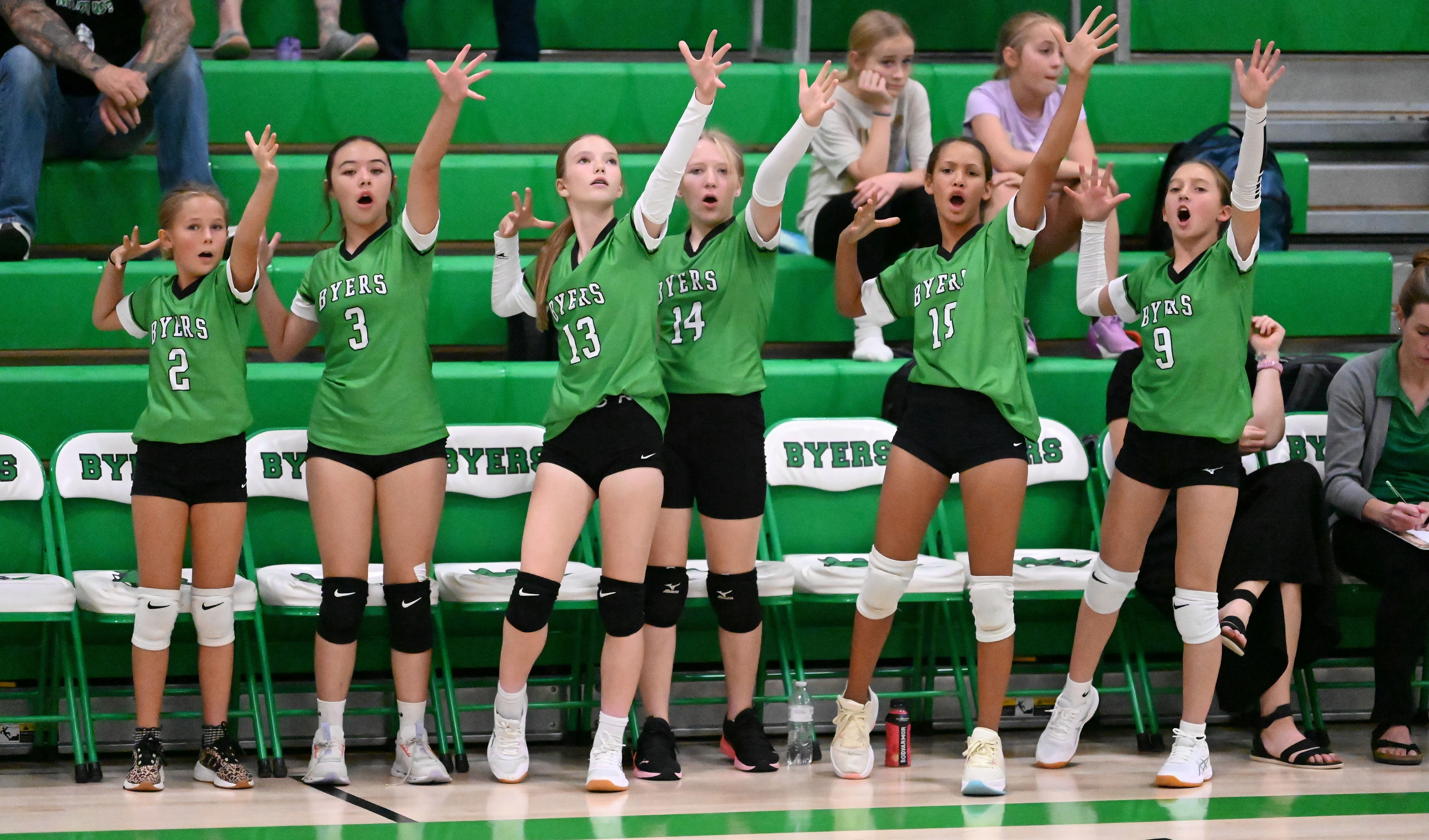 6 Byers players standing on the bench shooting a fake arrow into the air.