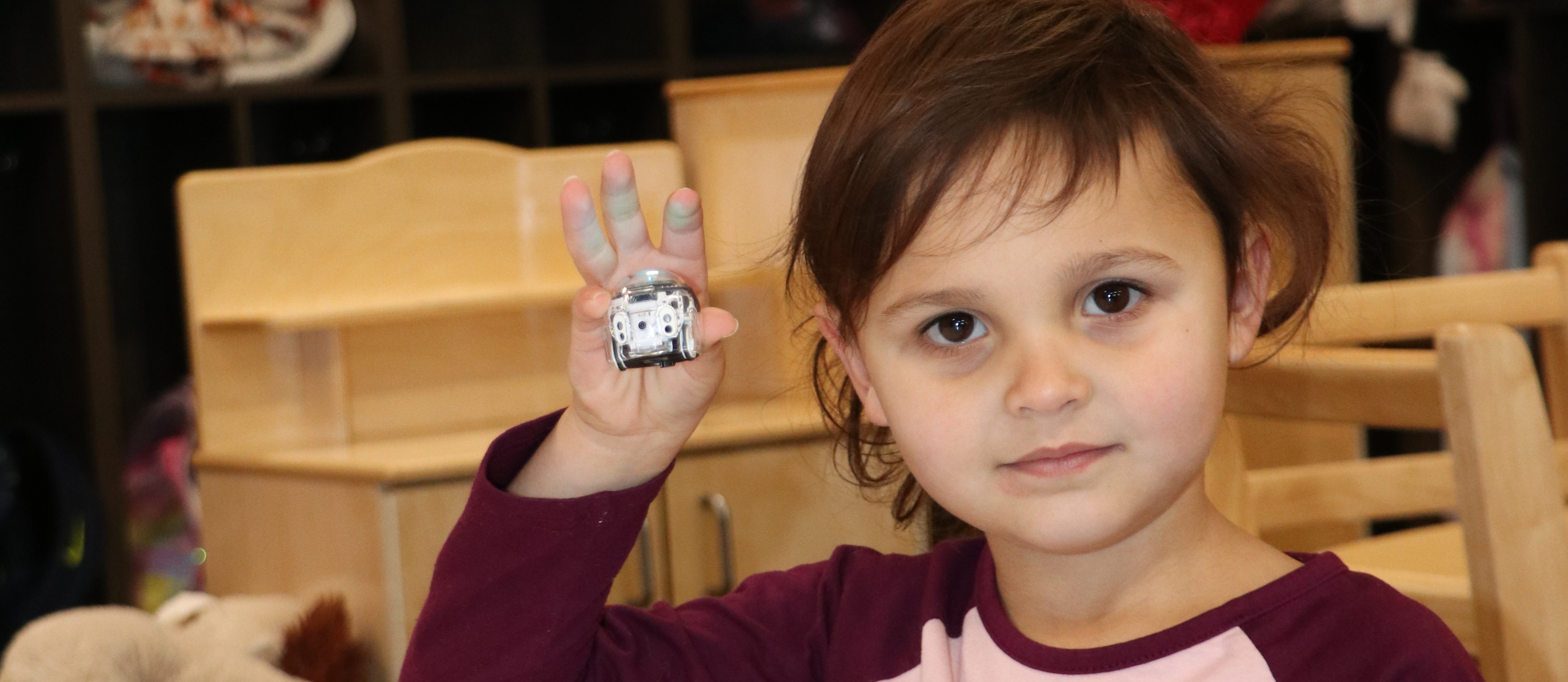 Preschooler shows her robot "Ozzie"
