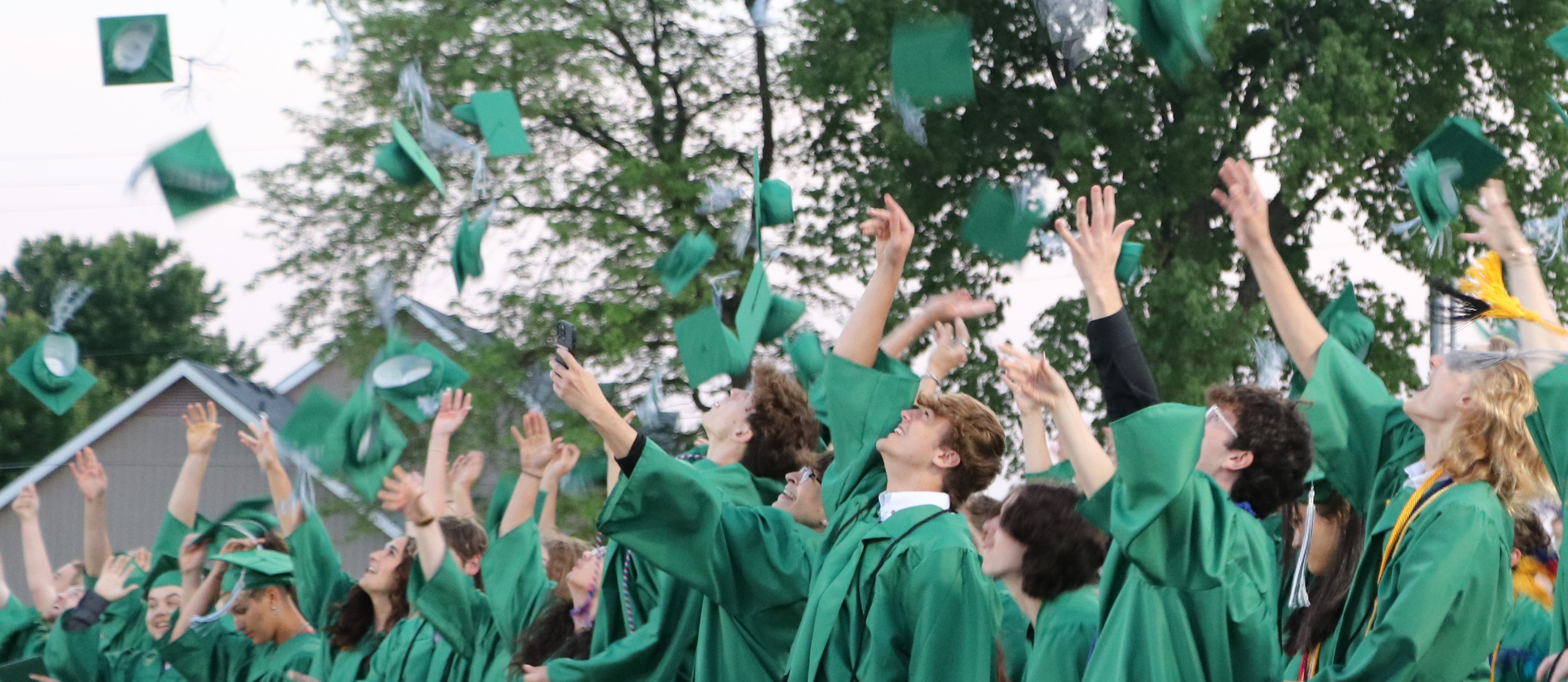 Graduates throw hats in air