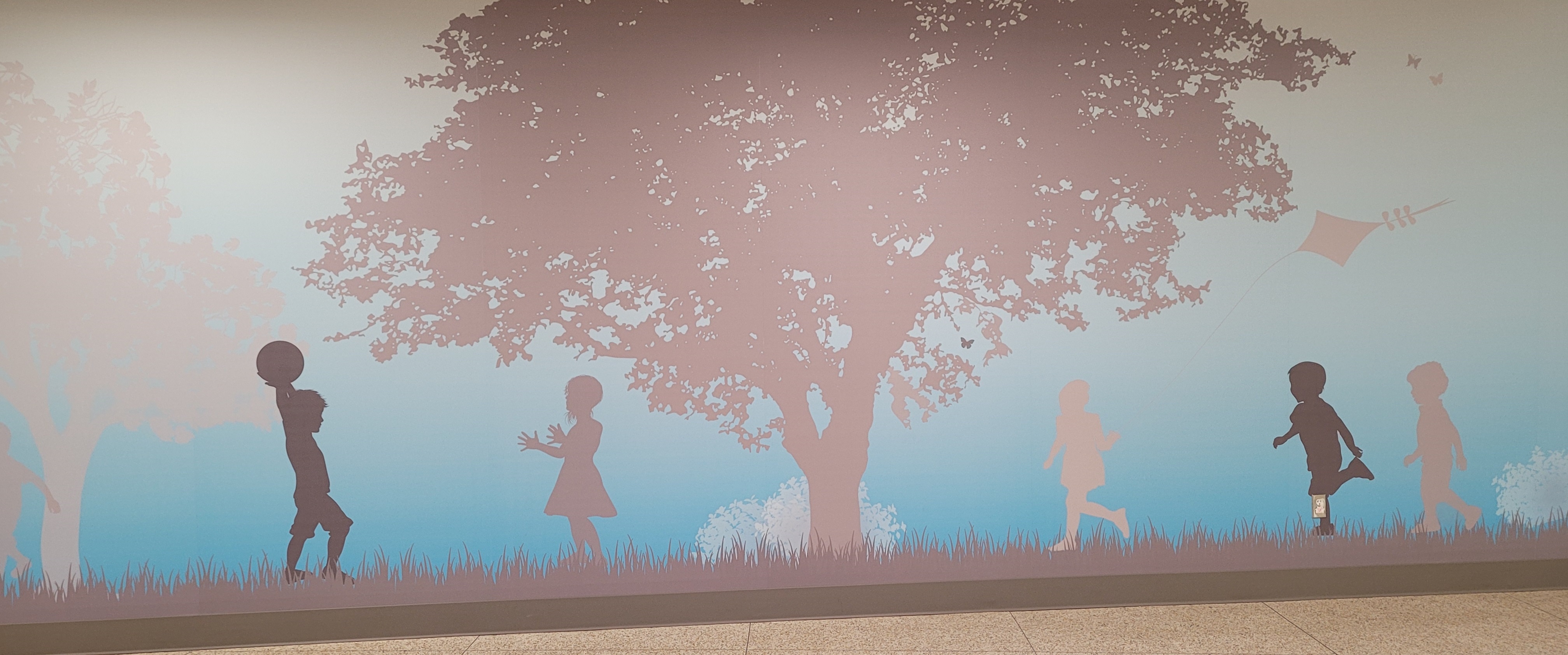 Children playing under a tree on a wall decal