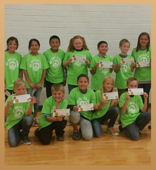 a large group of smiling children in matching green shirts