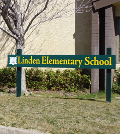a green sign that reads "Linden Elementary School" in yellow letters