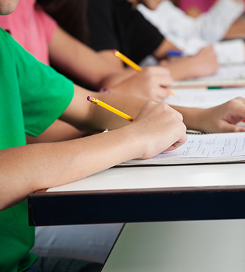 a close-up of a group of children's hands as they write