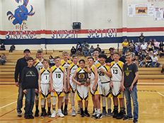 The SLJHS basketball team standing in the gym and holding a plaque