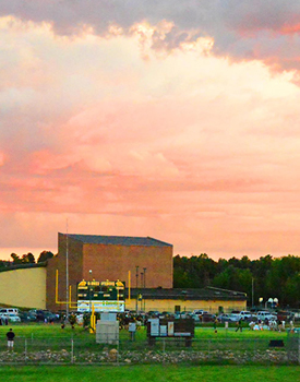 the football field under a cloudy sky at sunset