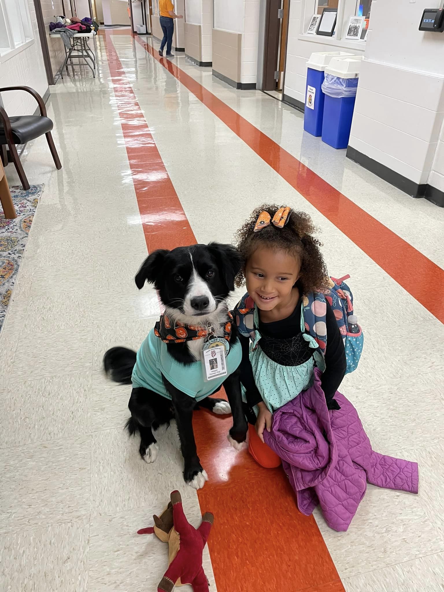 Maggie, the therapy dog, poses with a student.