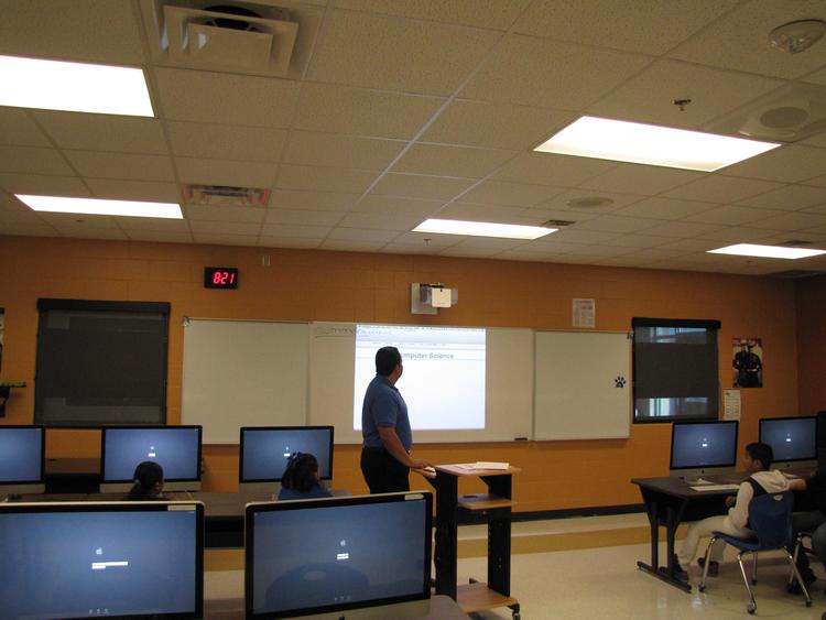 kids and teacher in front of computers learning