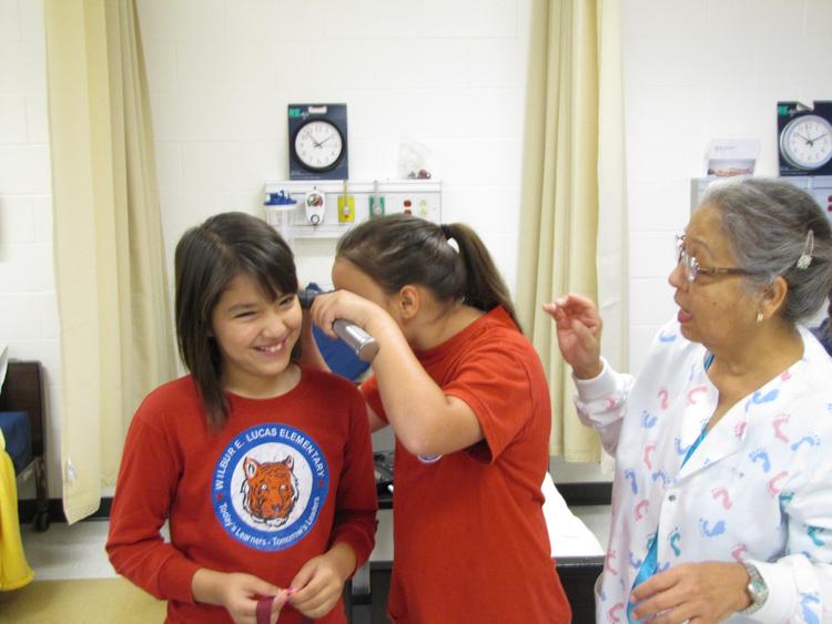 kids learning with a nurse inside of classroom