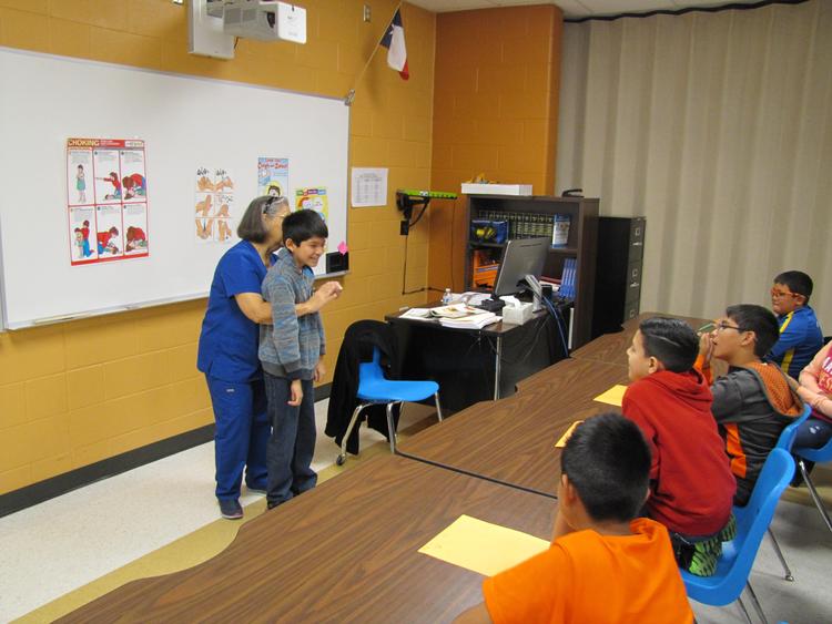 kids learning with a nurse inside of classroom