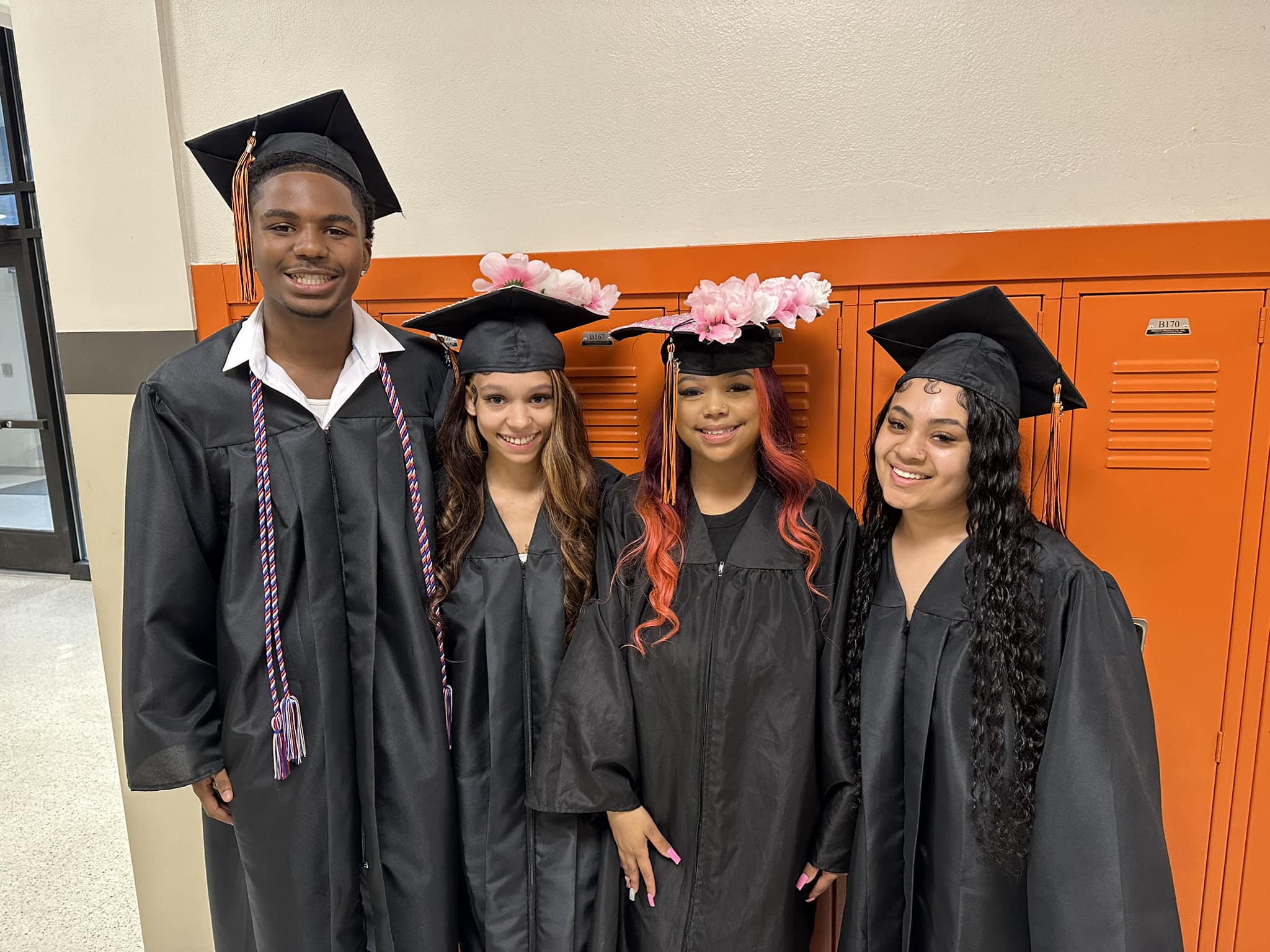 Graduates pose for a picture in the hallway at graduation