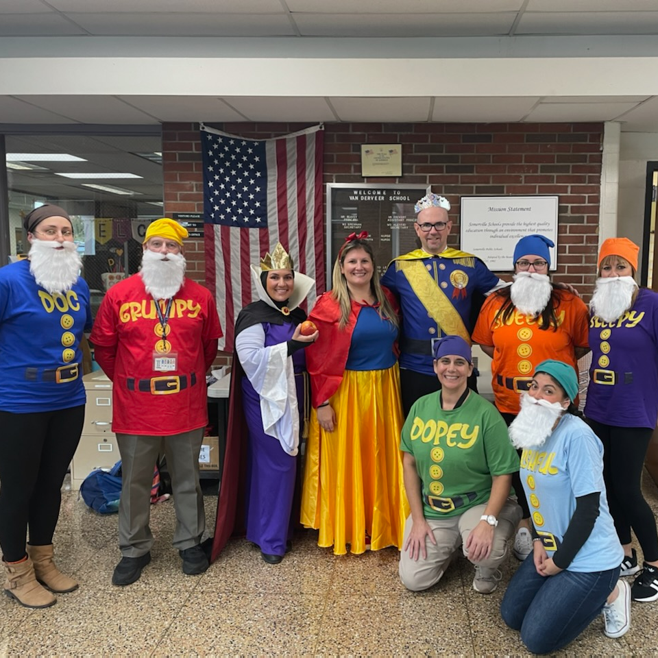 group of adults posing for the camera dressed as snow white and 7 dwarfs