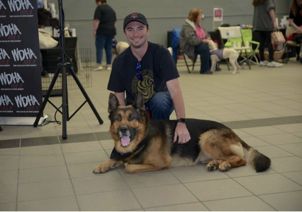 white male posing for the camera with a german shepherd