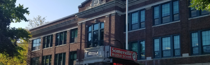 Somerville Middle School sign in redo and white Bulldogs in red  picture of the front old brick school building with the American flag red white an d blue on a  pole