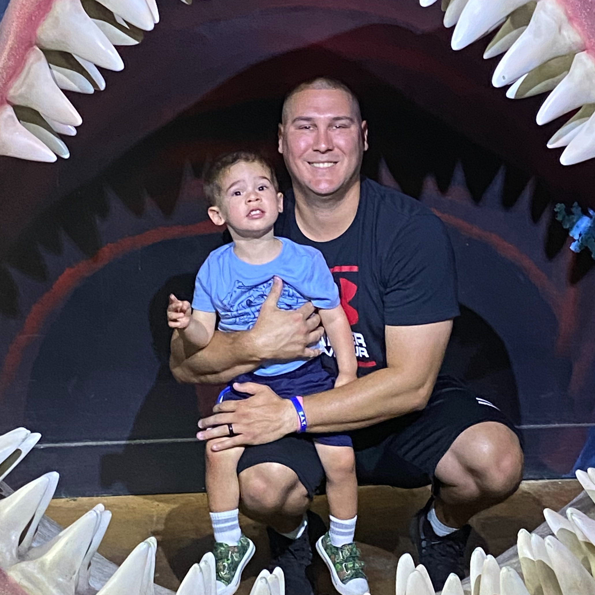 man and child posing inside shark mouth