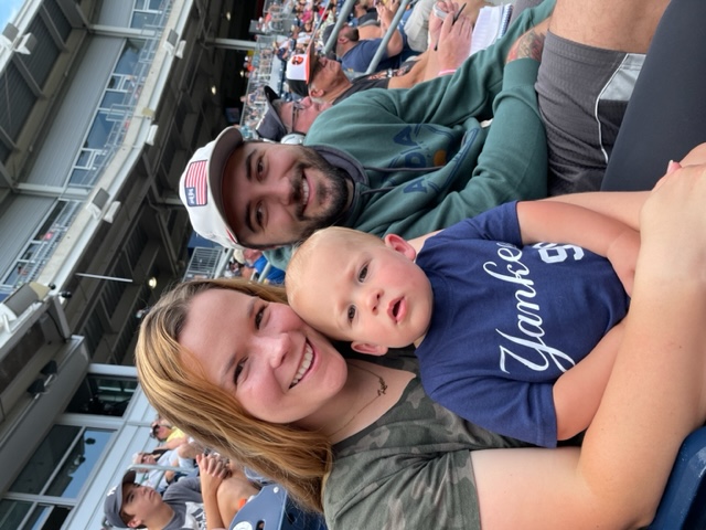 white male, female, and baby smiling for the camera