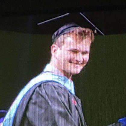 white male wearing graduation cap and gown